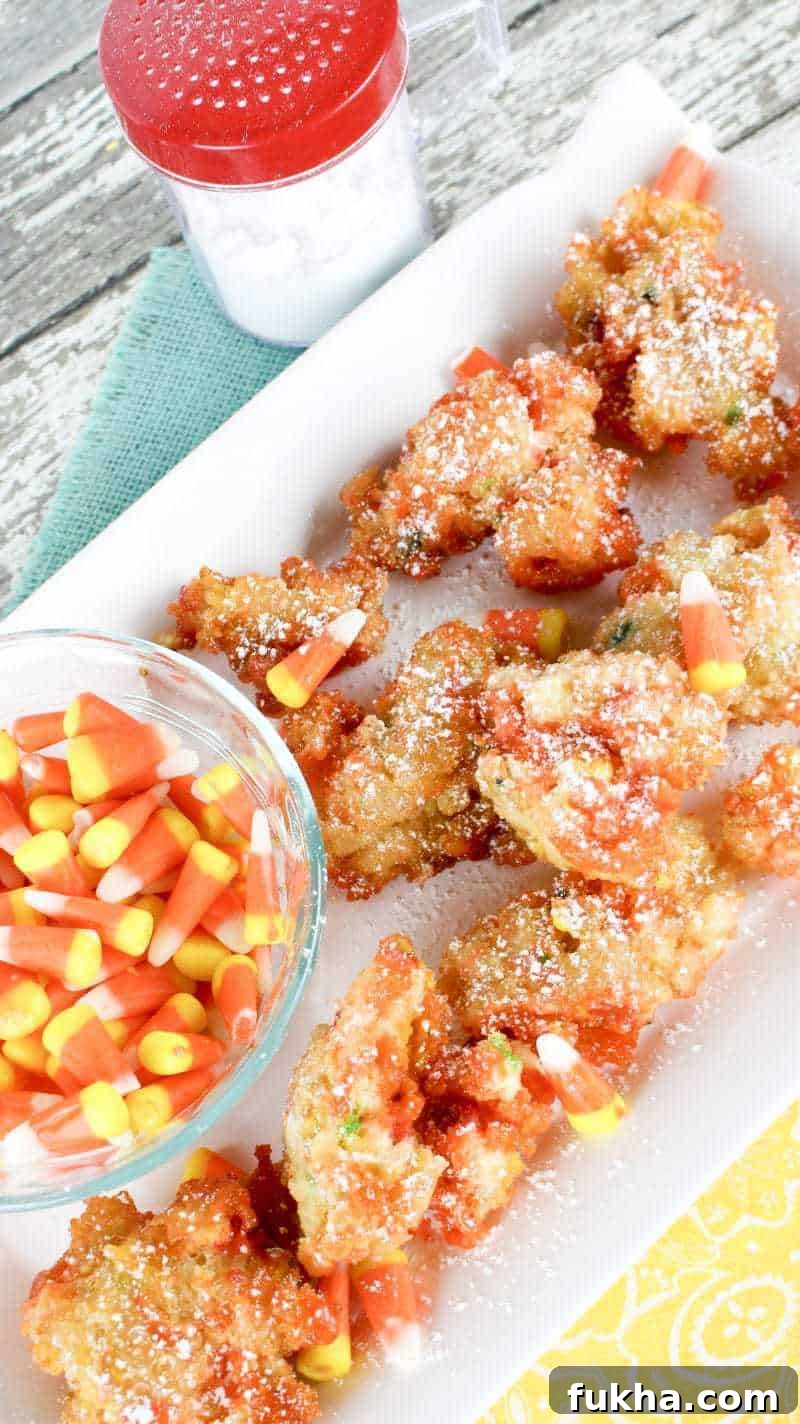 Candy corn fritters with bowl of candy corn and confectioners sugar in sugar duster.