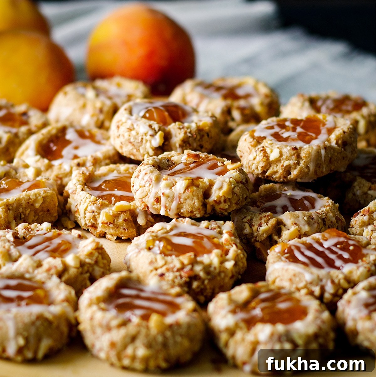 Freshly baked almond thumbprint cookies resting on a wood tray.