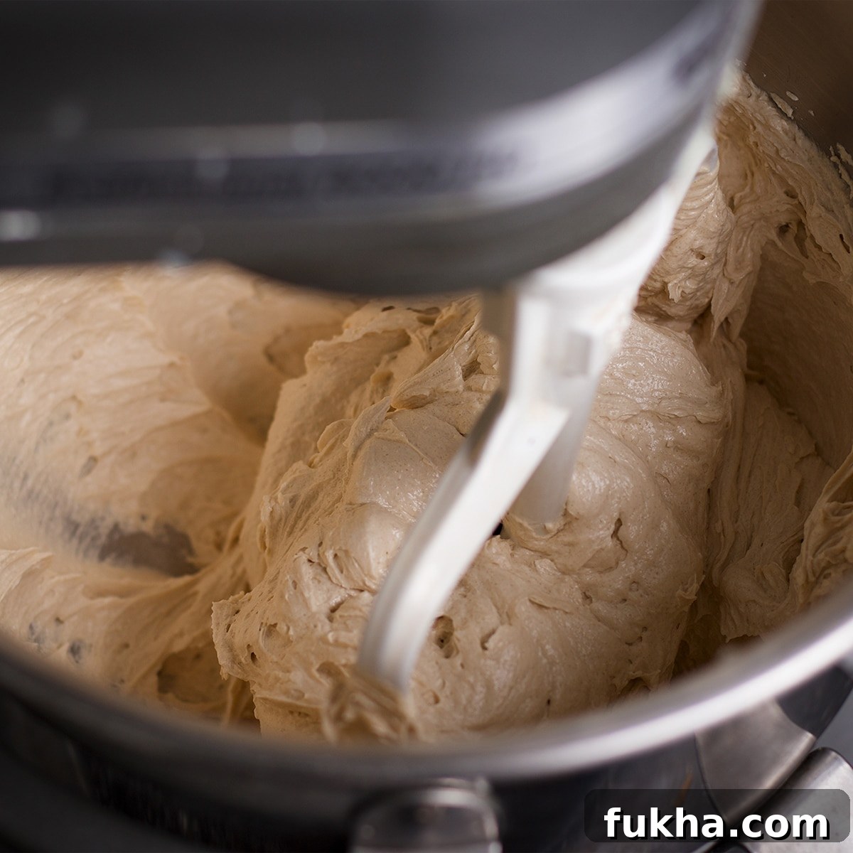 Using an electric mixer to beat butter with brown sugar and granulated sugar.