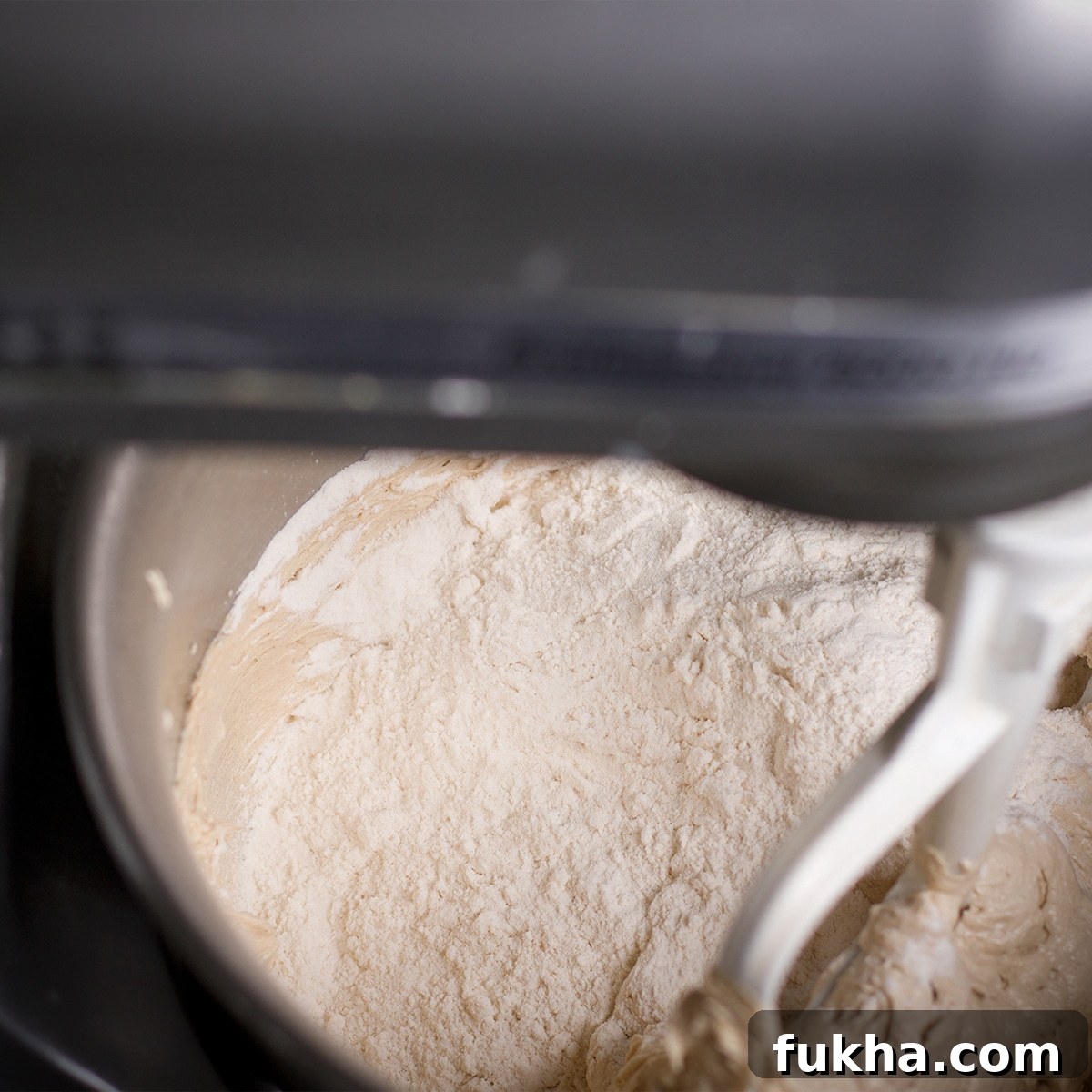 Mixing all-purpose flour and almond flour into cookie dough.
