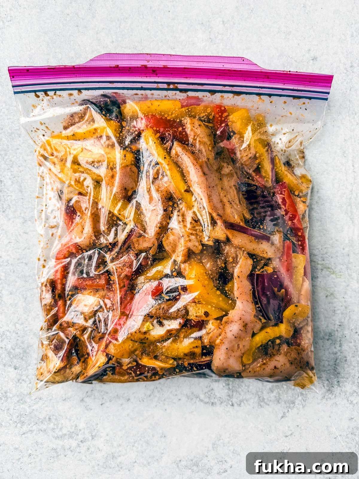 Gallon zip-top bag full of marinated chicken fajita ingredients.