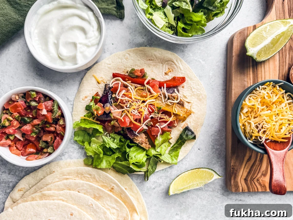 Chicken on tortilla prepared with toppings with bowls of cheese, lettuce, and pico de gallo next to it.