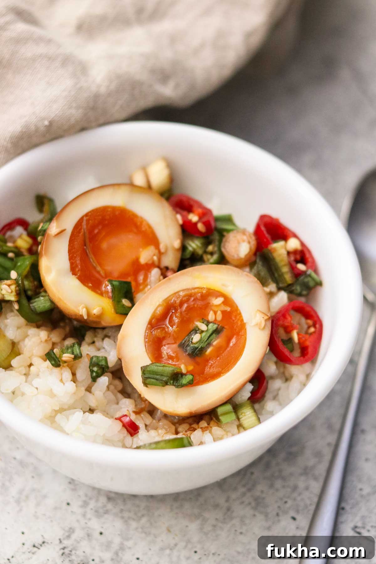 A sliced Mayak egg served over rice in a bowl