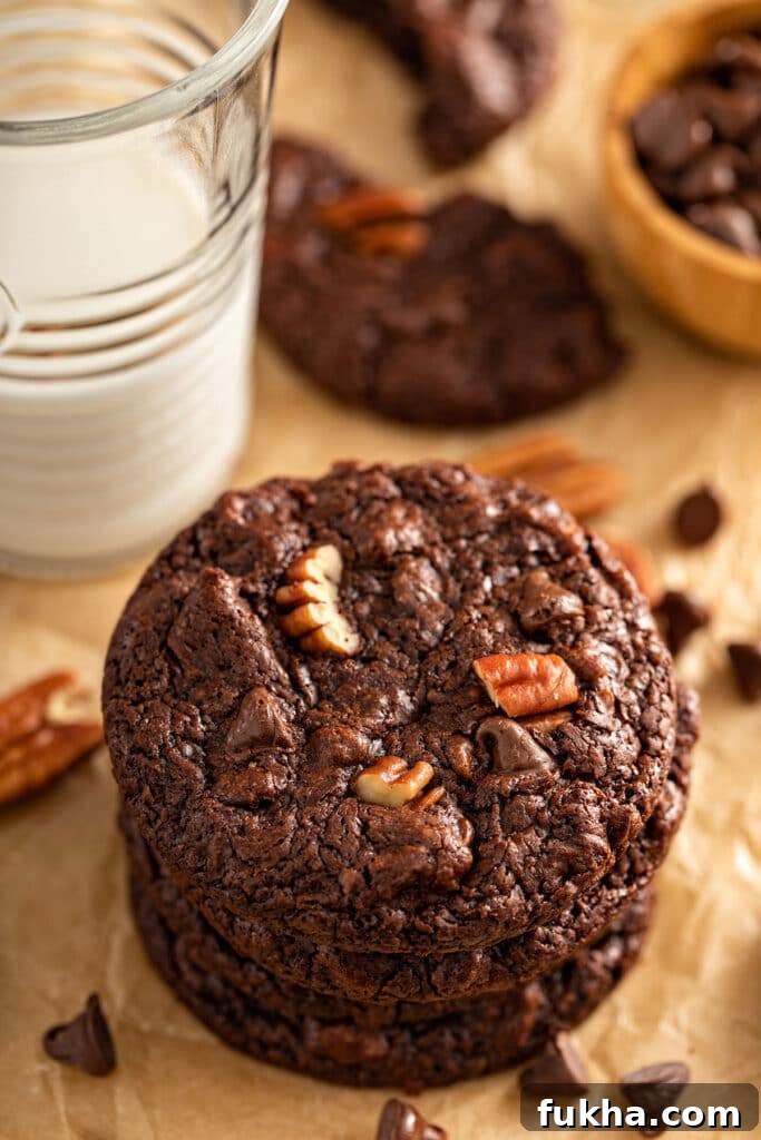 Photo showing the top of a double chocolate cookie studded with pecans and chocolate chips.