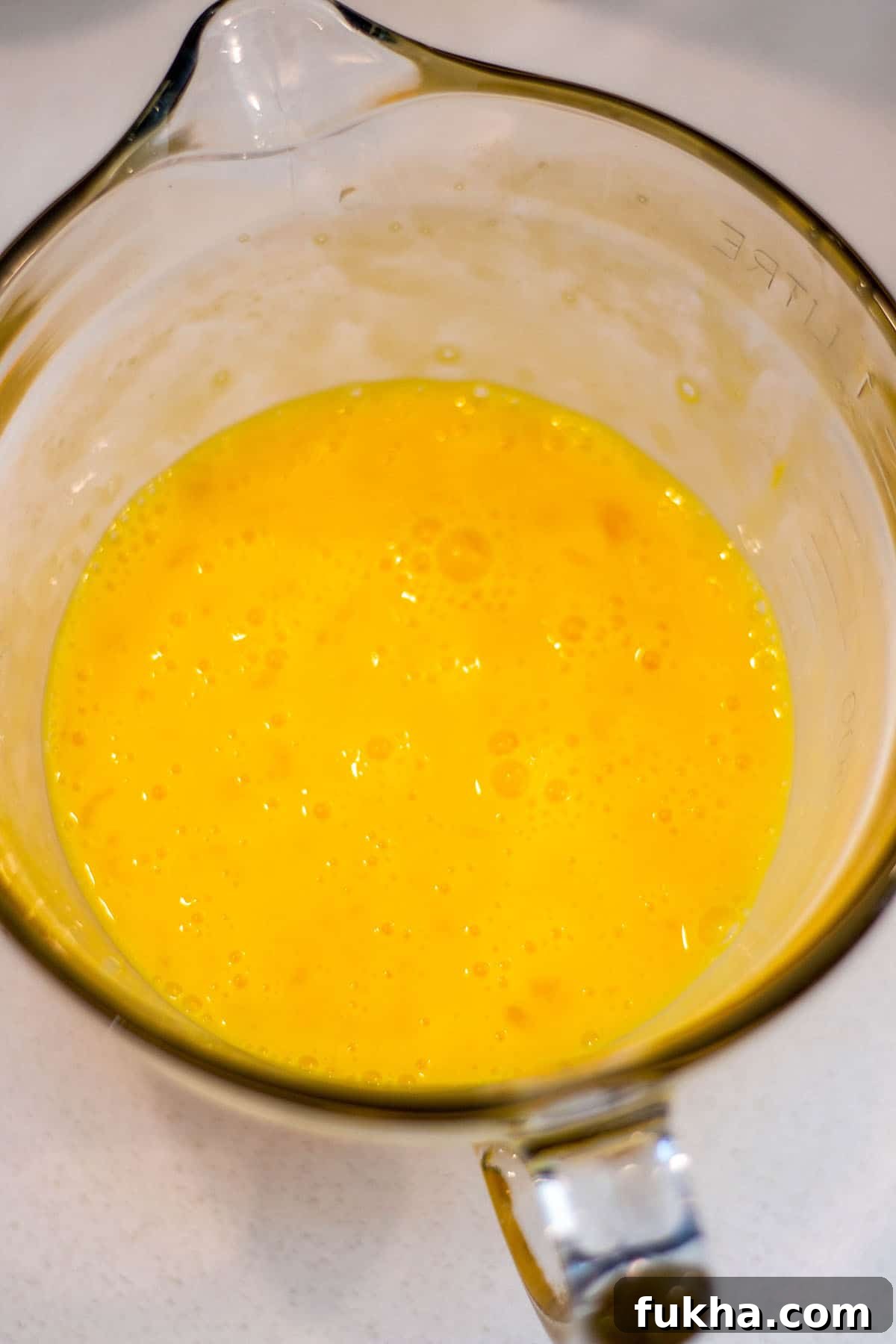 Sourdough Starter Breakfast Bites Recipe 4 A glass batter bowl with whisked eggs.