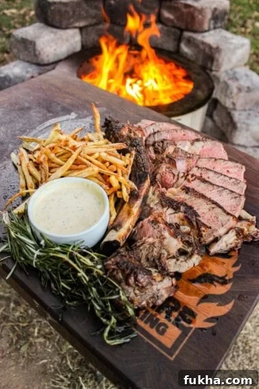 The grilled ribeye with beef tallow fries on a cutting board.
