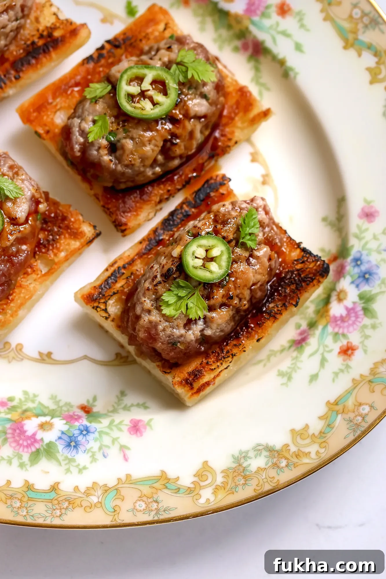 Overhead view of tuna tartare on toasted baguette with serrano and herbs