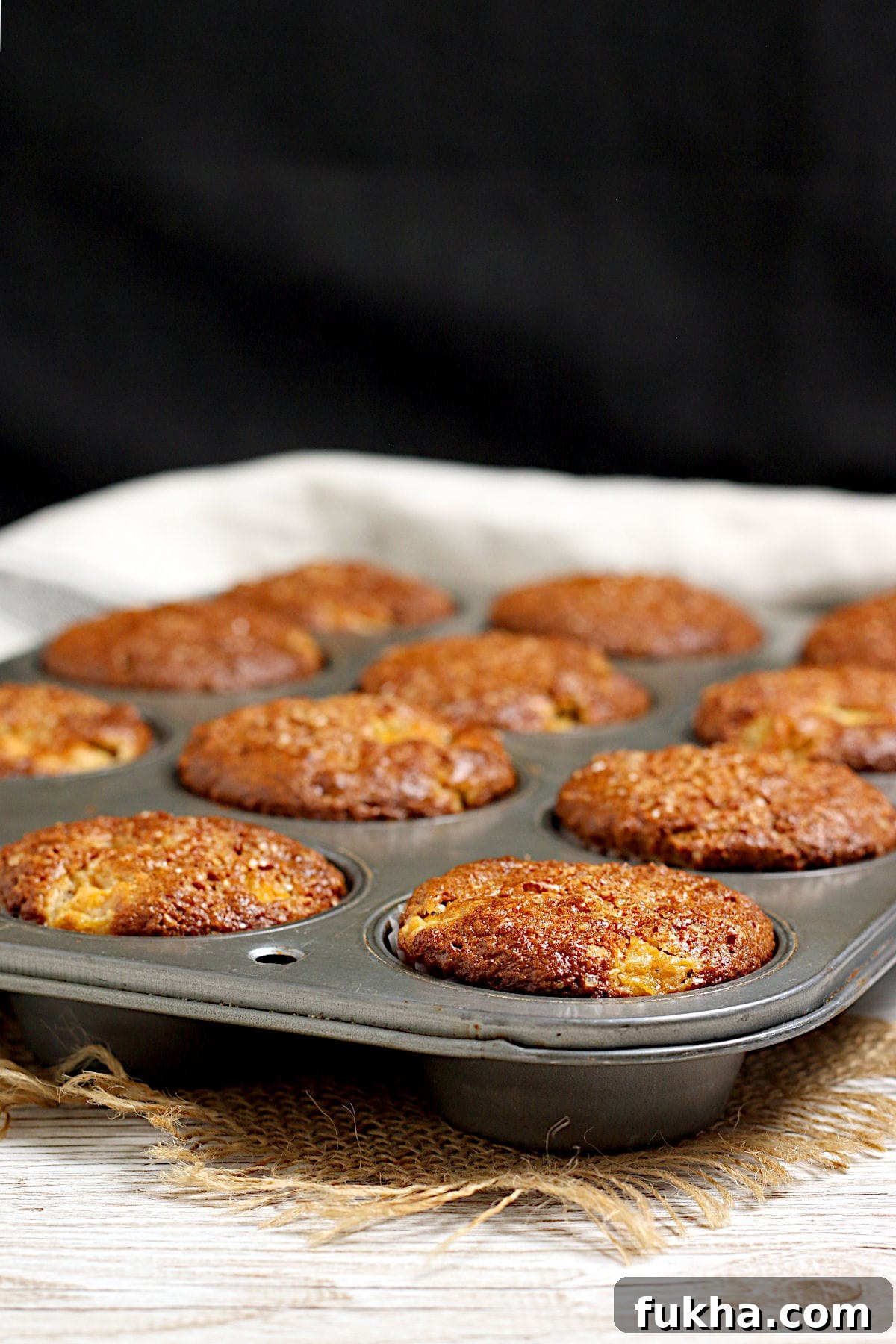 Peaches and Cream Oatmeal Muffins in a muffin pan.
