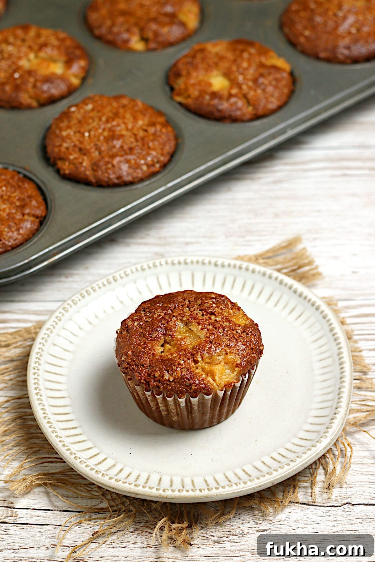 A Peaches and Cream Oatmeal Muffin on a small white plate.
