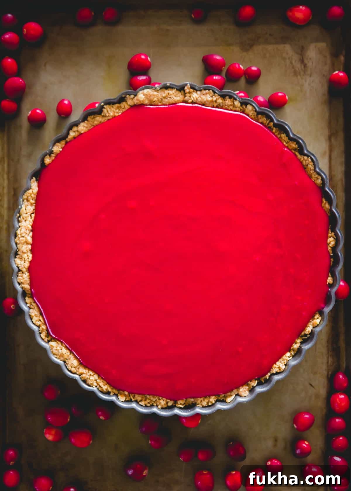 Easy cranberry curd tart with oat and walnut tart crust before setting.