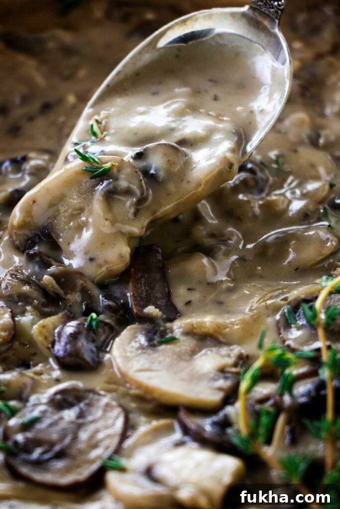 A spoon scooping some mushroom marsala sauce.