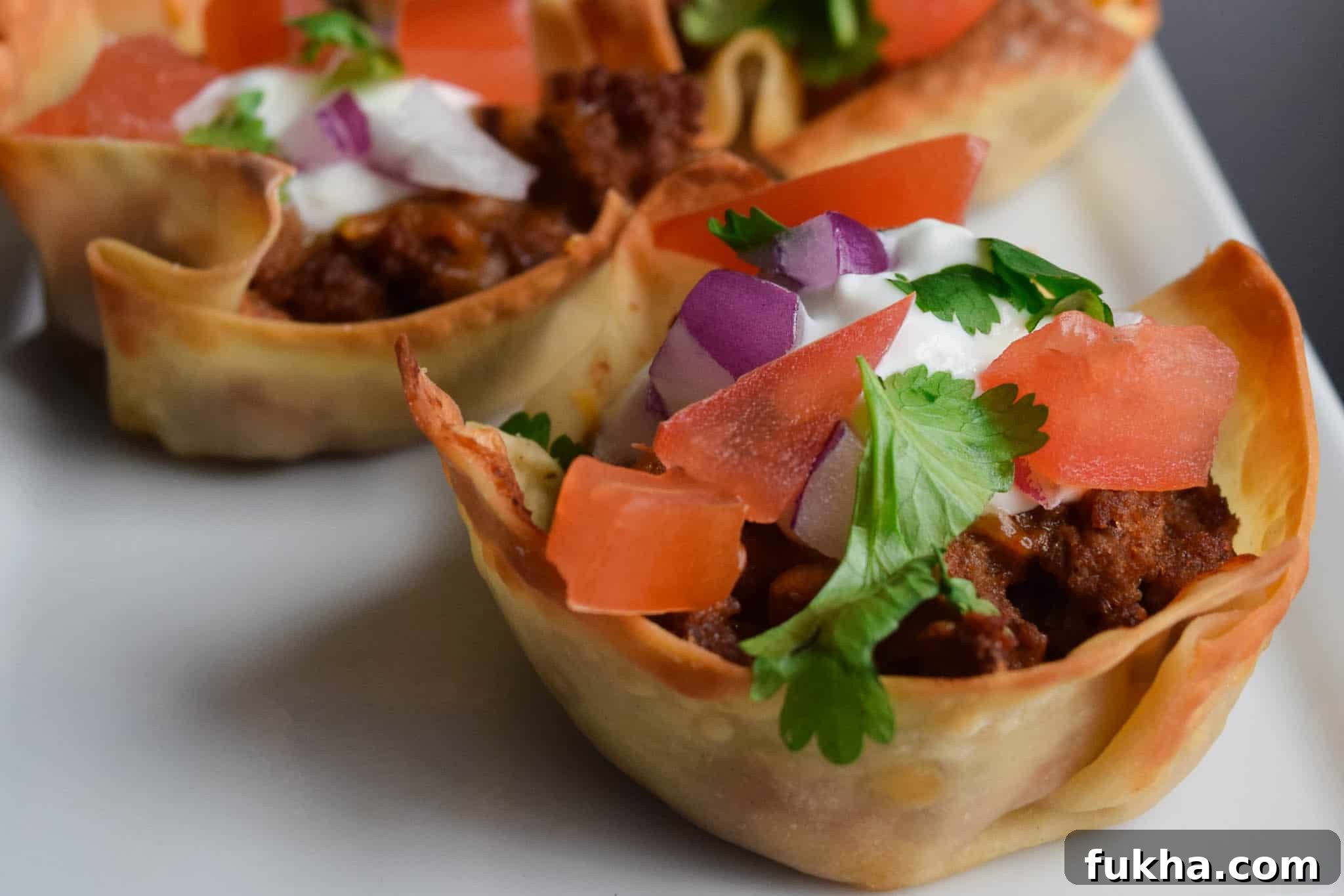 Taco Wonton Cups Recipe for Parties 3 taco won ton cup topped with taco toppings close up view