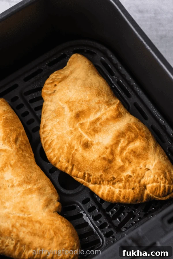 Close up of calzones in the air fryer basket.