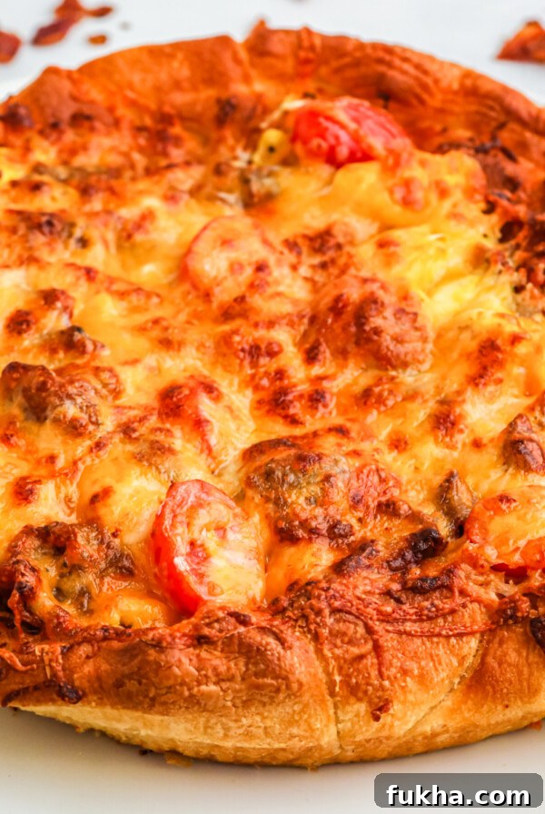 Breakfast pizza on a white plate ready to slice and serve.