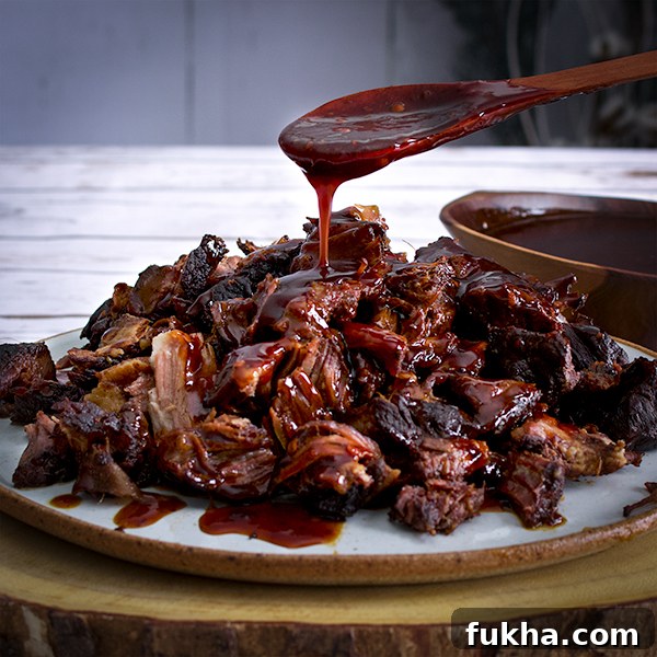 Pouring sauce over a plate of Asian Short Ribs.