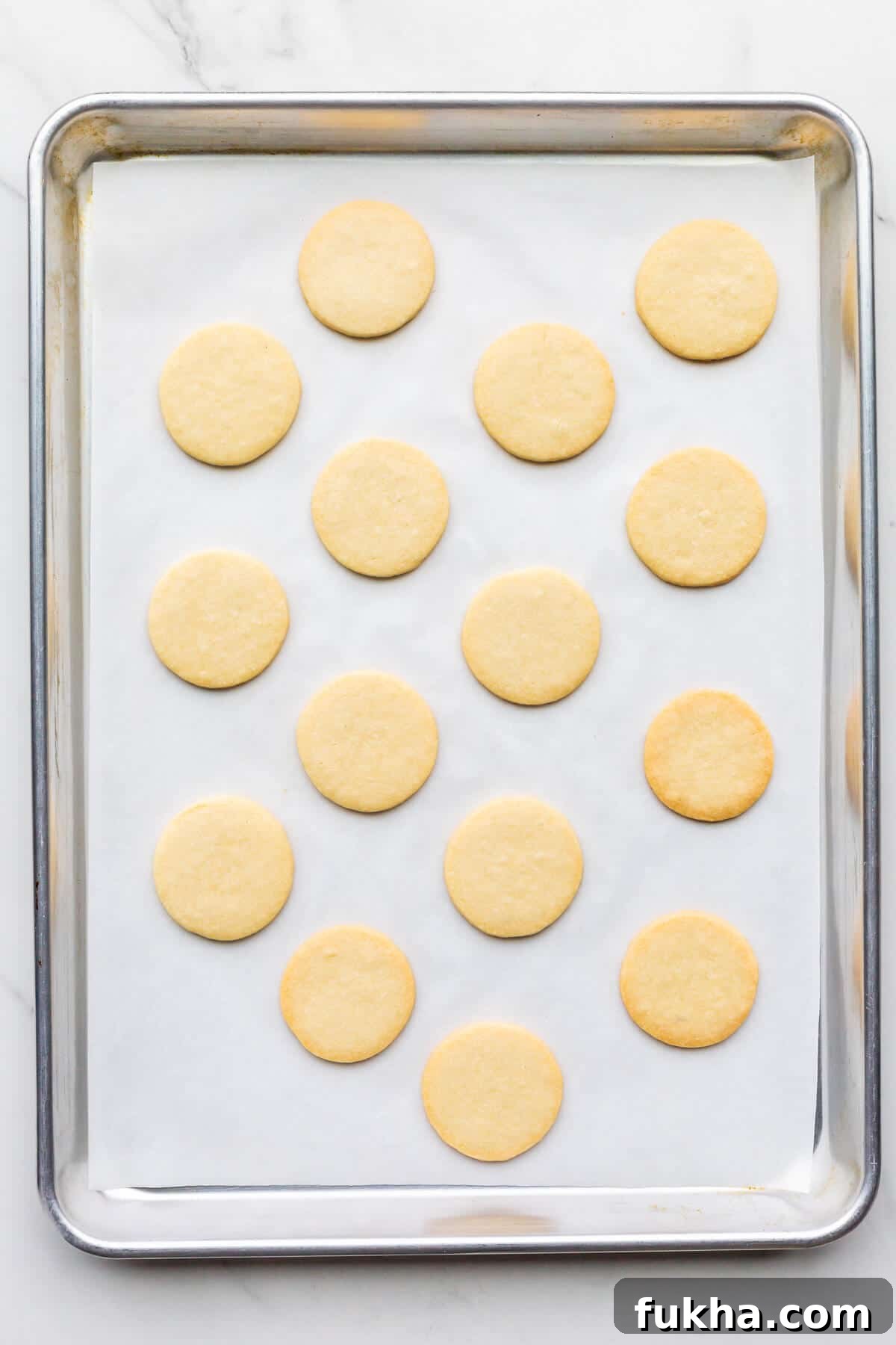 Freshly baked shortbread cookie cutouts on a sheet pan.
