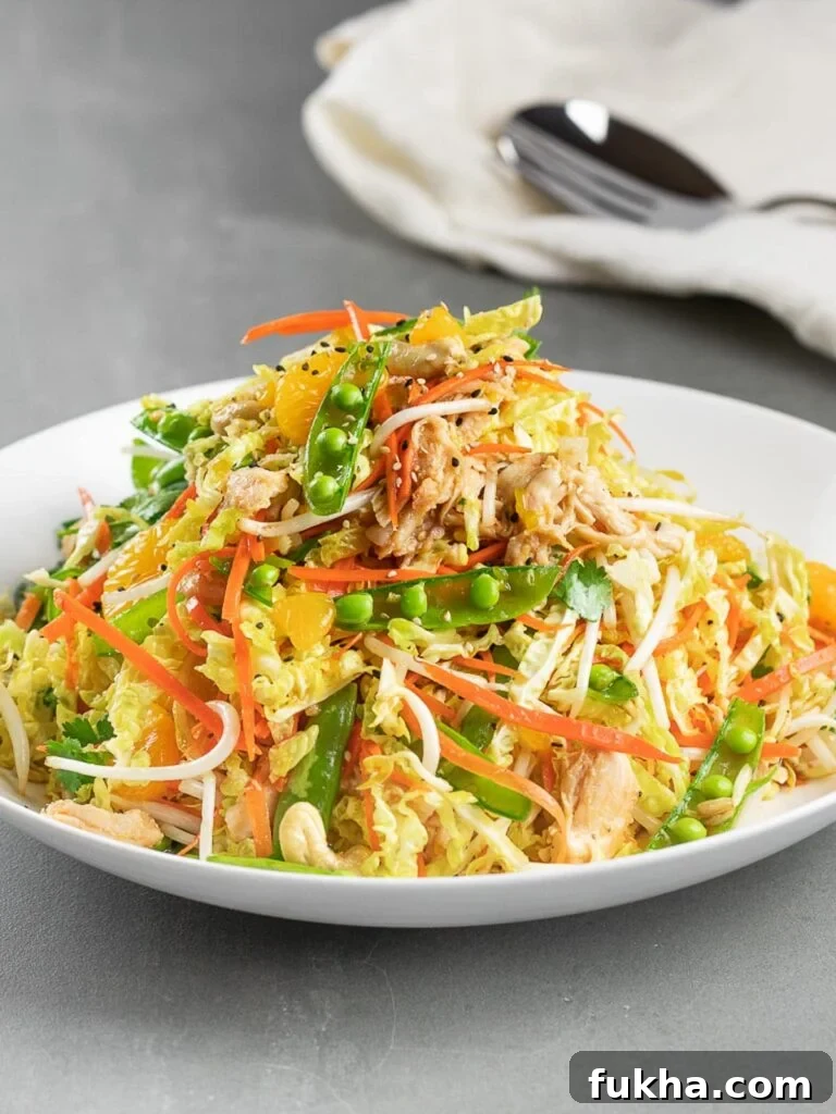 healthy Chinese chicken salad in a white bowl and grey tile