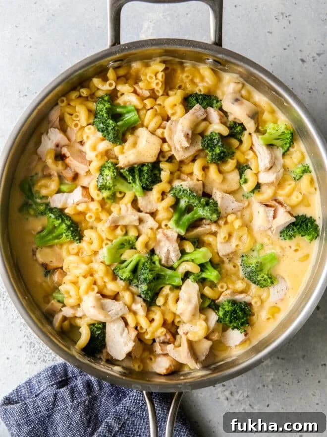 chicken broccoli macaroni and cheese in a skillet with towel