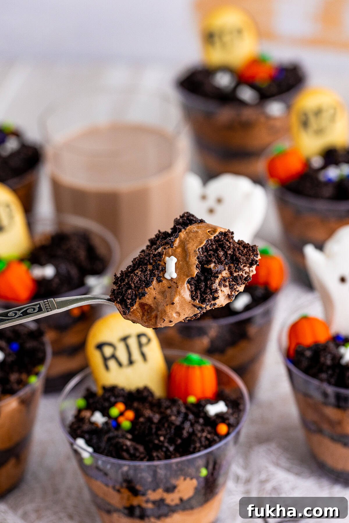 Graveyard Dirt Cups Recipe for Halloween 7 Spoon holding up some of the pudding from cups.