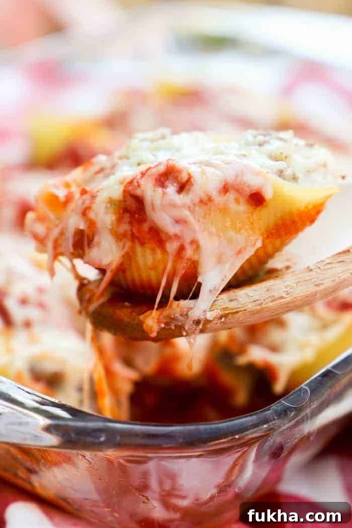 Baked Lasagna-Stuffed Shells Recipe 4 Lasagna Stuffed Shells on a wooden spoon