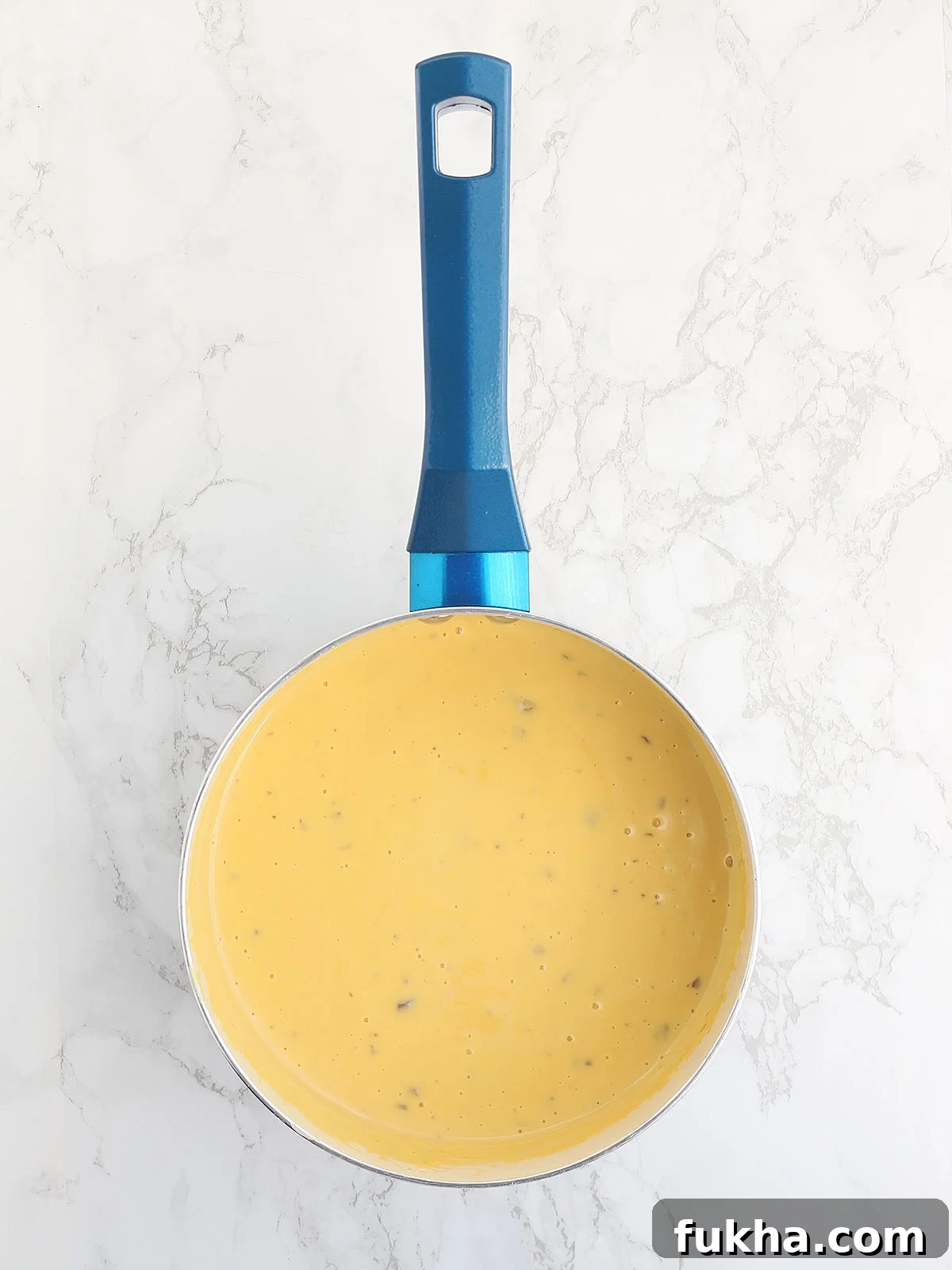 Creamy Broccoli Cheese Casserole 6 melted cheese sauce in a blue saucepan