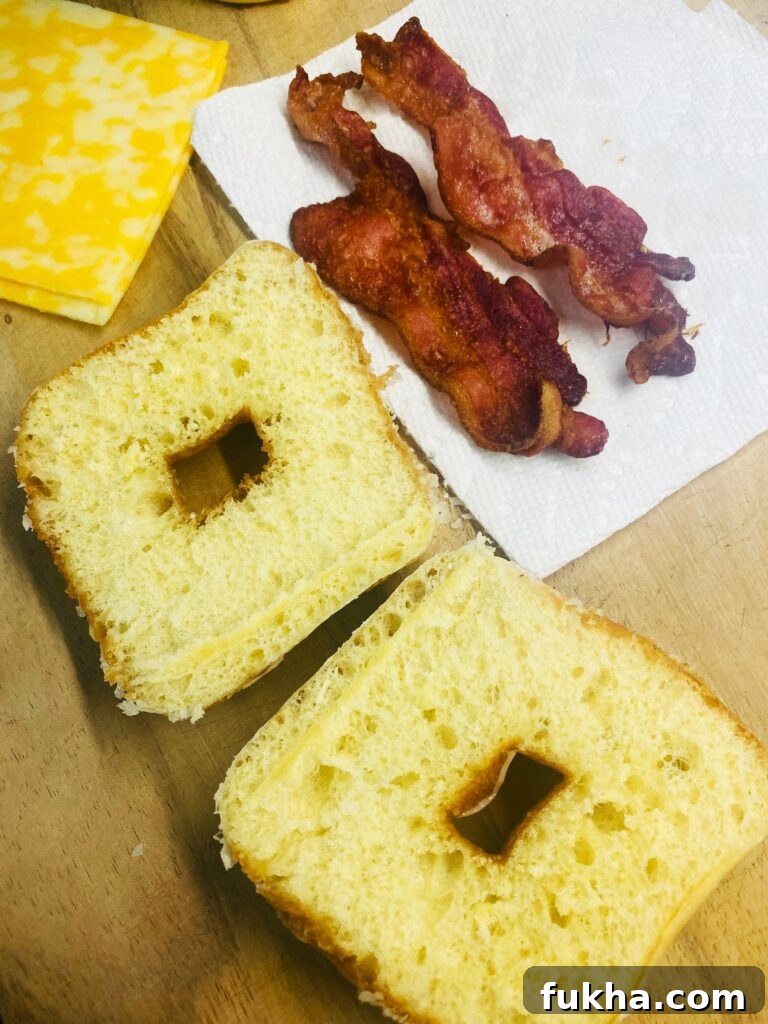 Cooked bacon and a sliced glazed donut ready for assembly