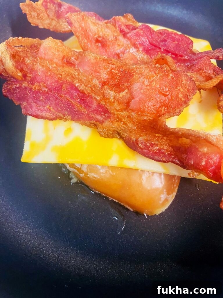 Adding cheese and bacon to the donut halves