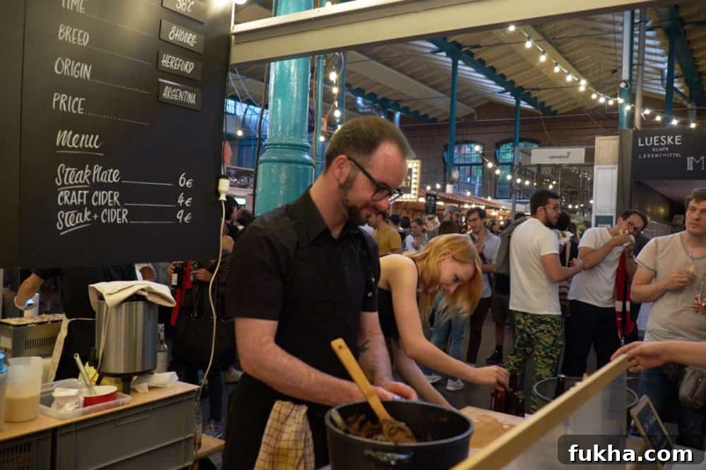 24-Hour Berlin Food Guide: What to Eat in a Day 3 A man preparing food at a Berlin indoor market.