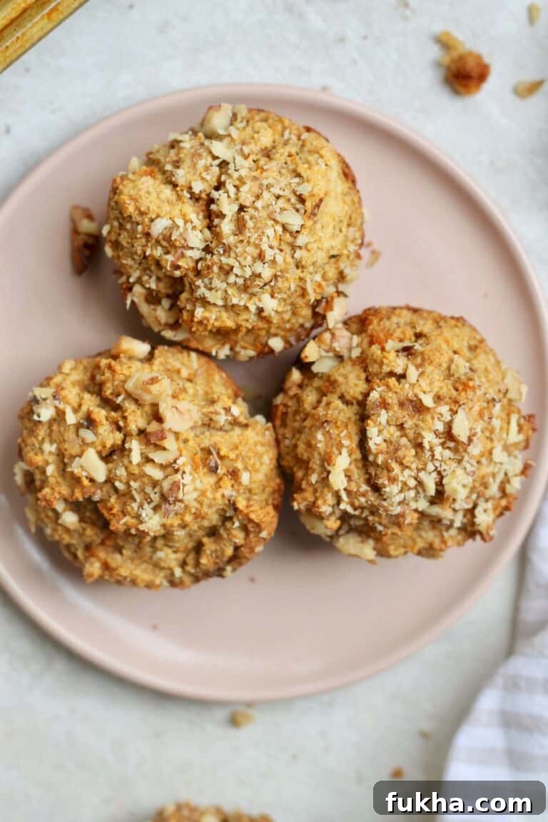 three muffins with nuts on pink plate