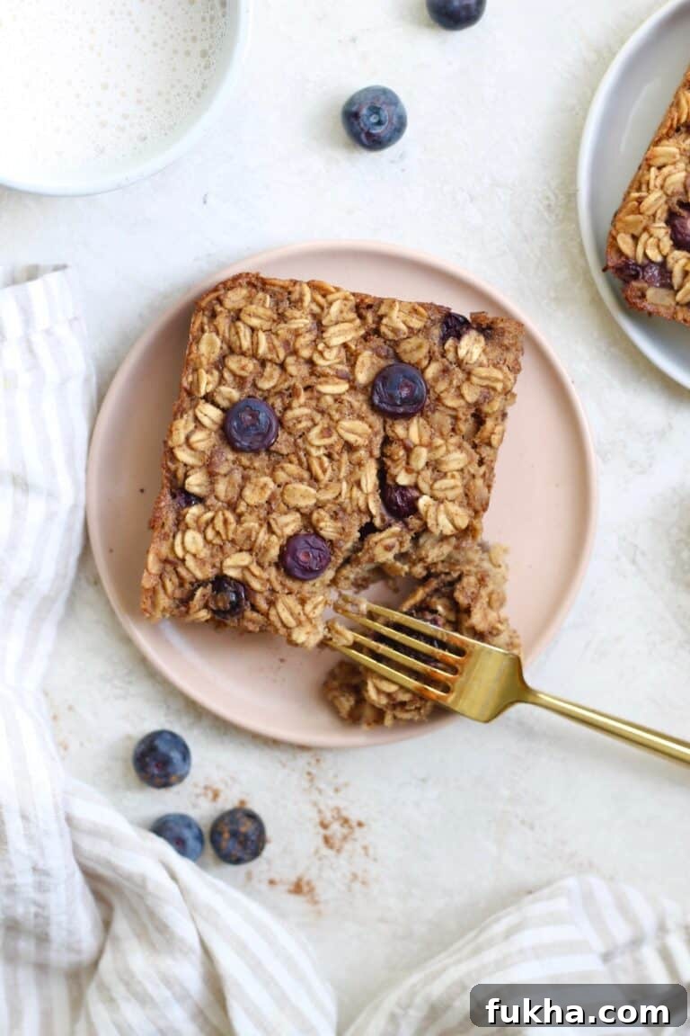 pink plate with baked oatmeal, blueberries and golf fork