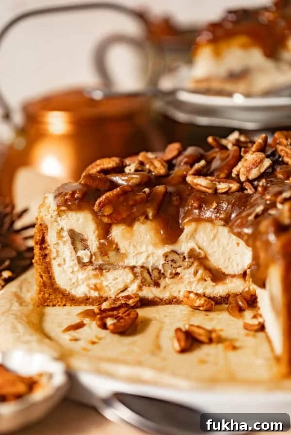 Creamy Pistachio Cheesecake Recipe 12 sliced pecan pie cheesecake on a serving plate topped with pecan pie filling.