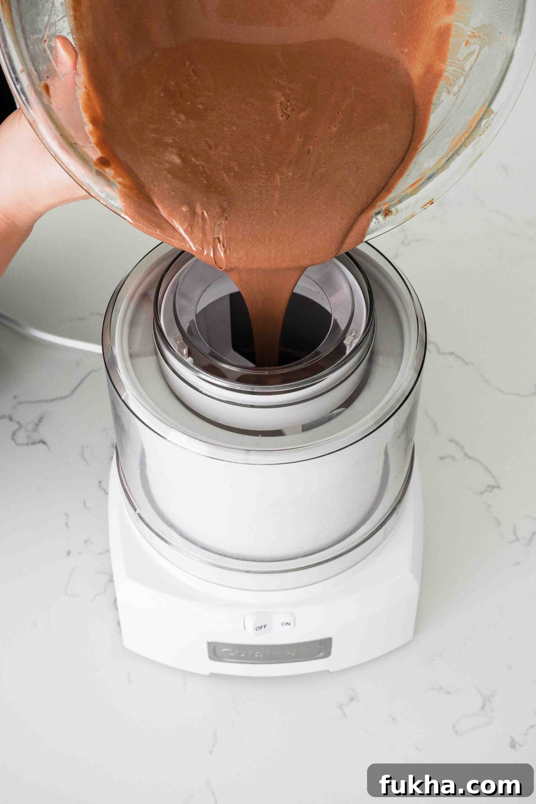 Chocolate custard is poured into an ice cream maker.