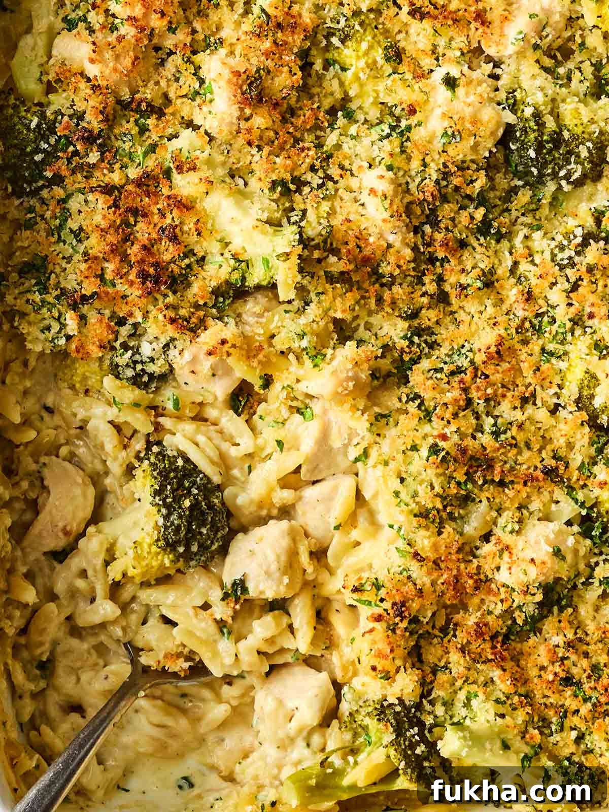 Dump-and-Bake Chicken Kyiv with Creamy Orzo 3 A close up of a one pan meal, with orzo pasta, chicken chunks, broccoli and a crusty topping, with a creamy sauce.