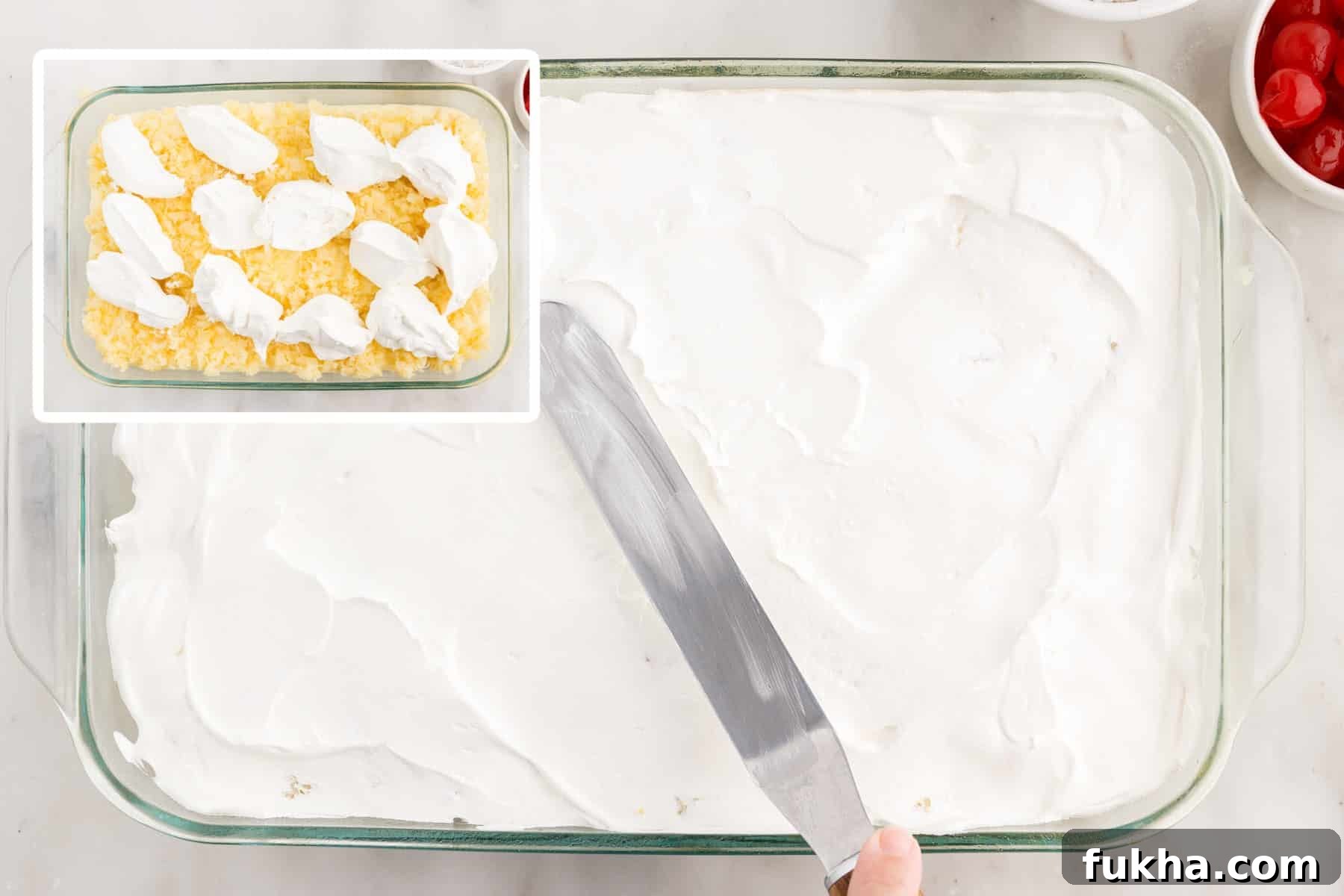 Cool Whip being spread on top of the cake.