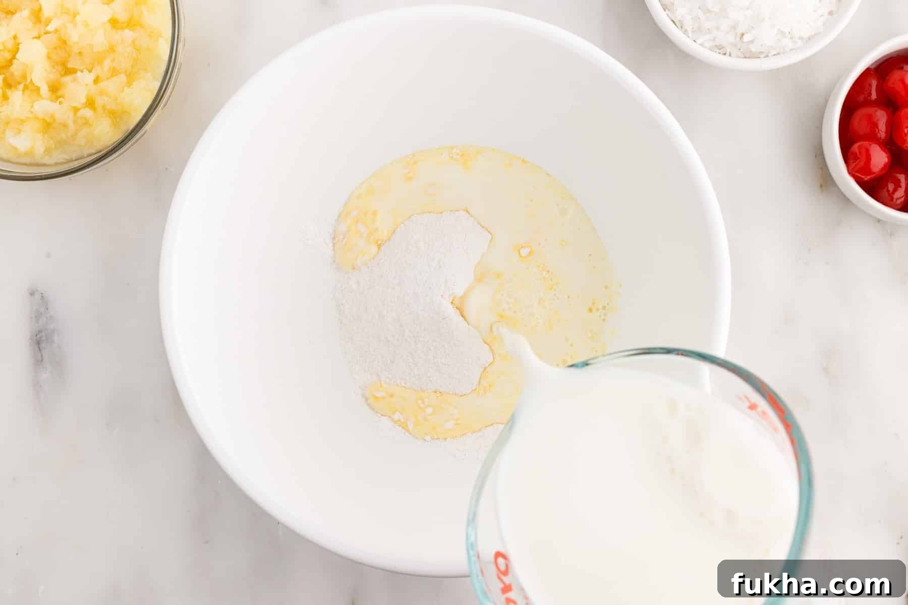 Vanilla pudding and milk combined in a mixing bowl.