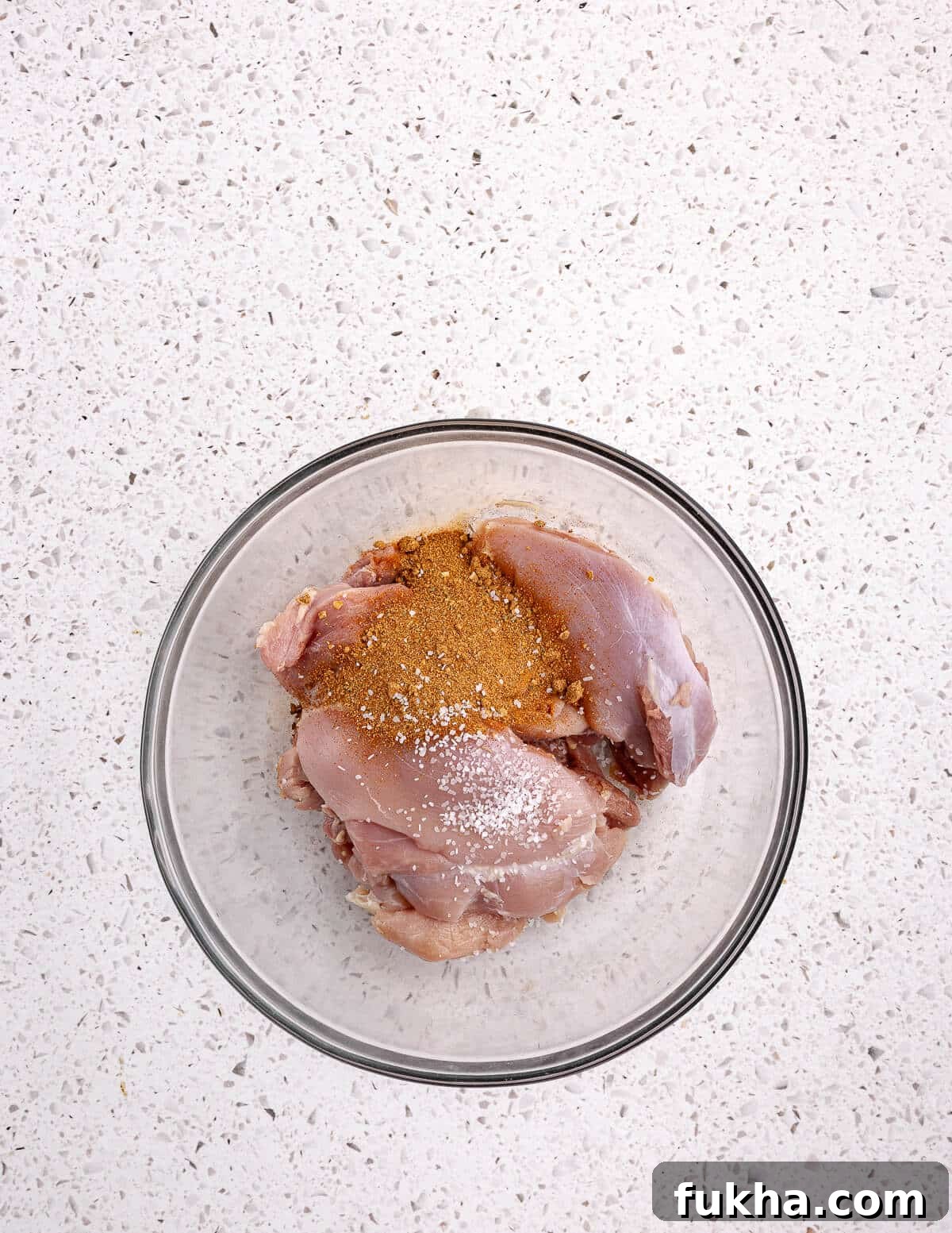 a bowl of chicken thighs with taco seasoning on them. 