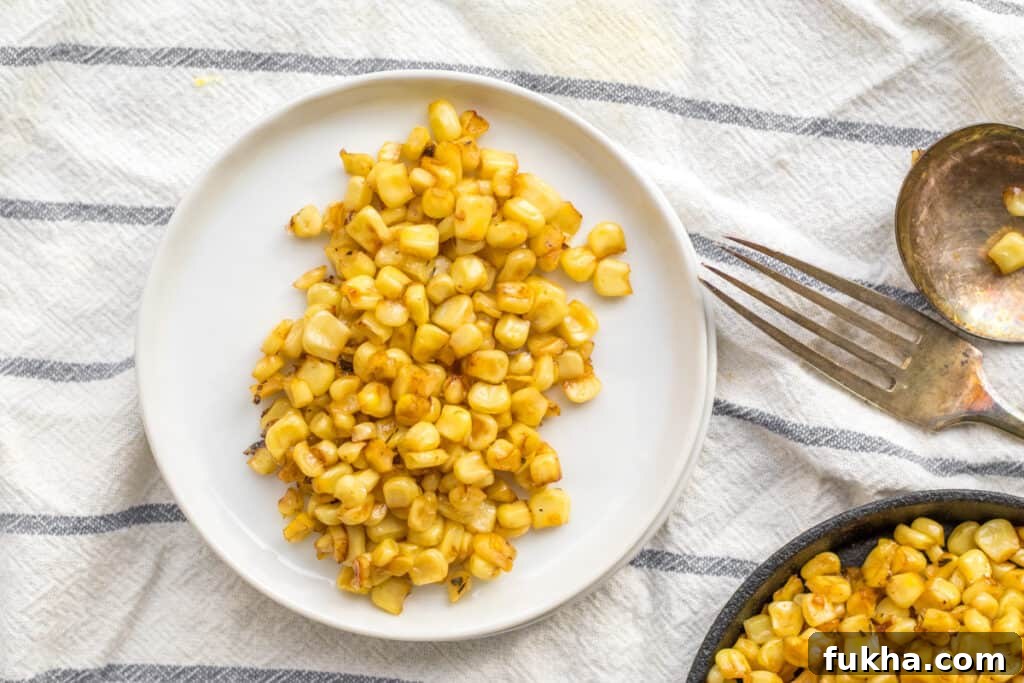 Smoky Charred Corn on the Cob Recipe 7 corn on a white plate with a fork