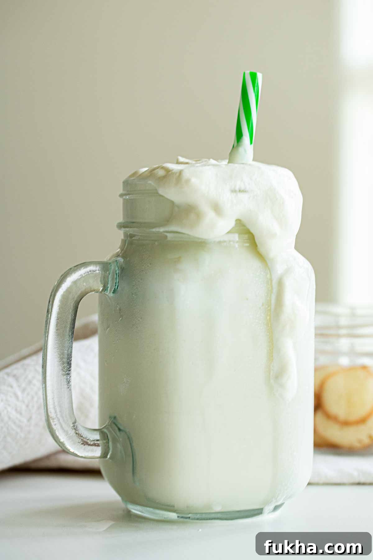 homemade Starbucks vanilla bean frappuccino drink with a green straw.