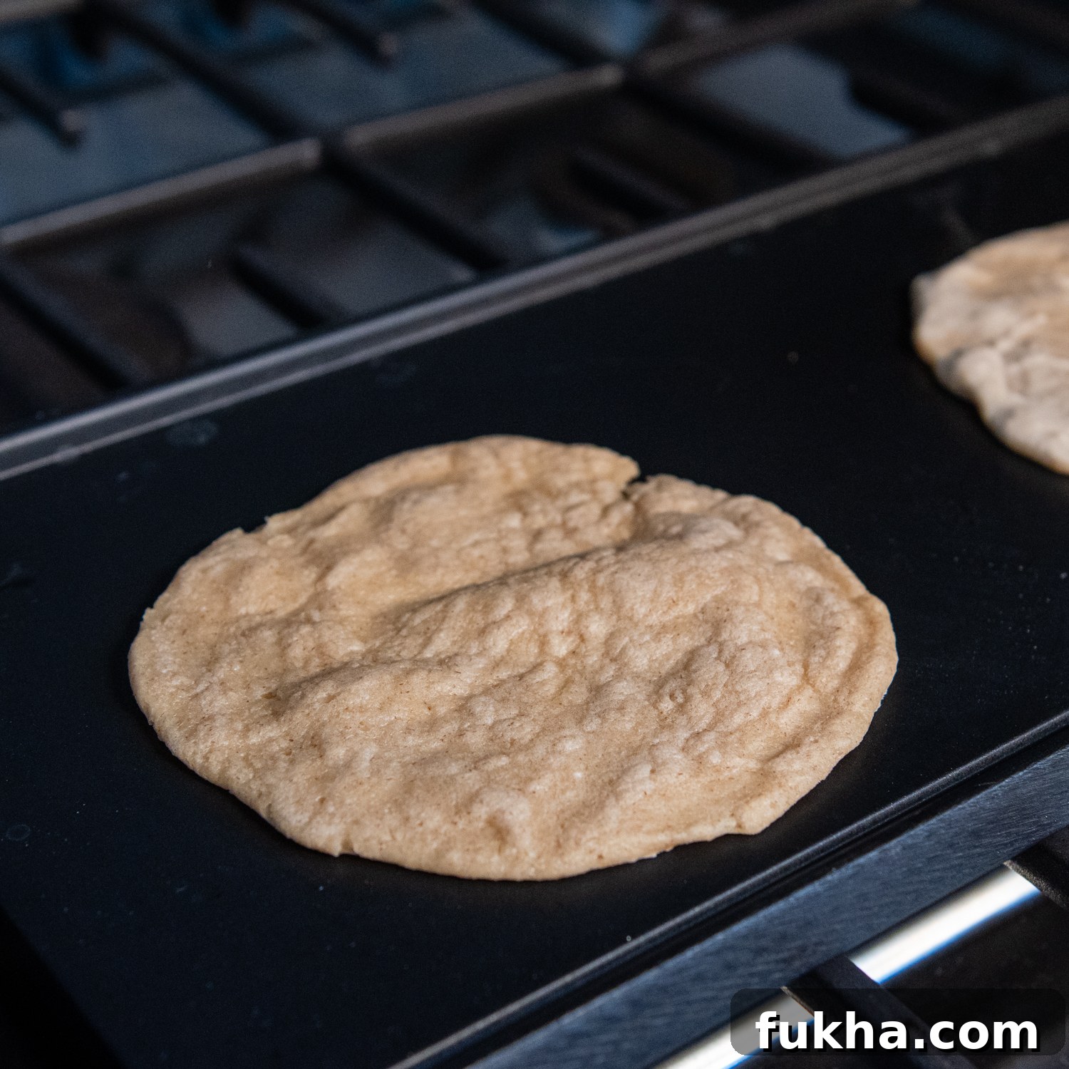 Tortilla cooking on a griddle.