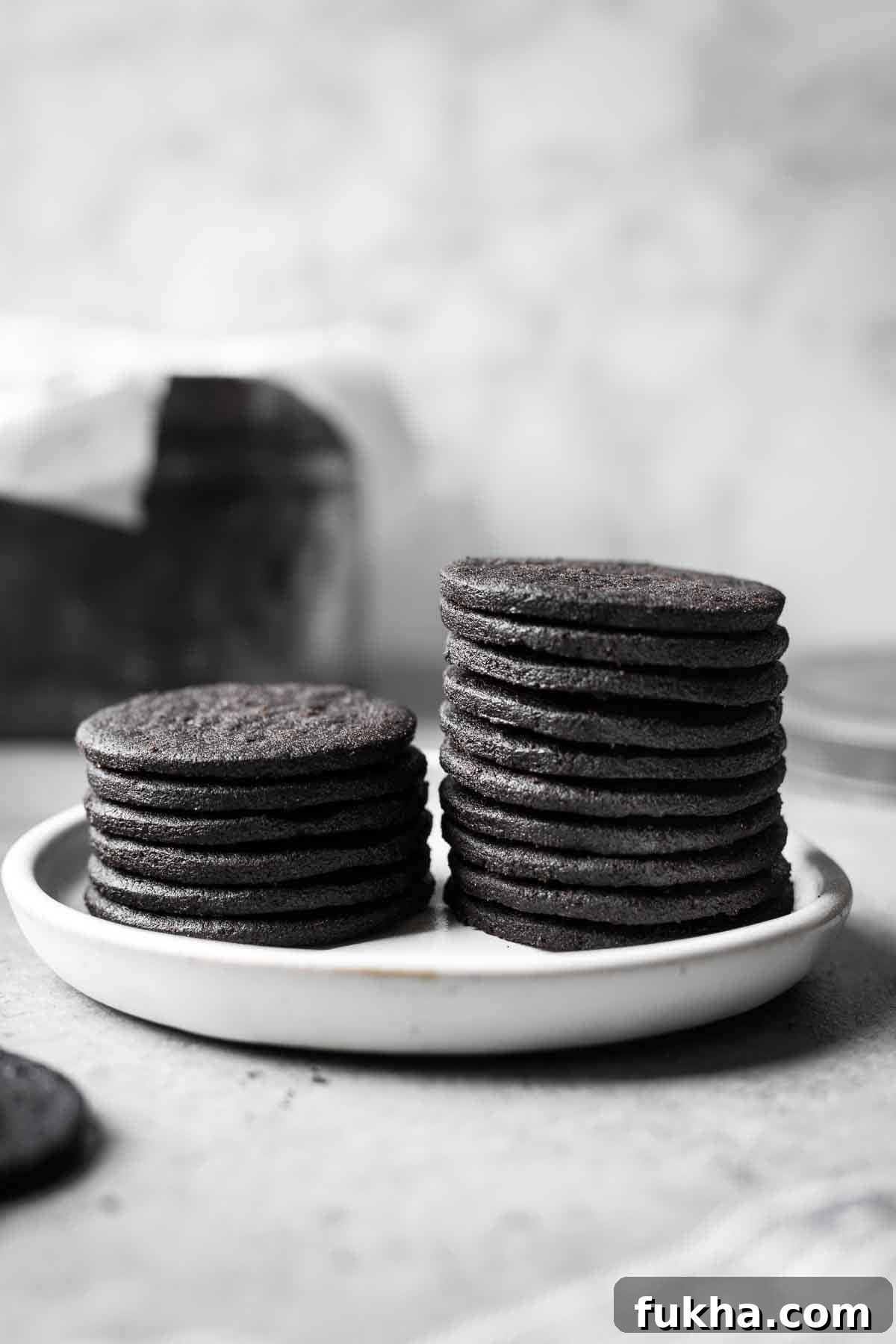 Crispy Homemade Chocolate Wafer Cookies Recipe 13 Two stacks of chocolate wafer cookies on a small ceramic plate.