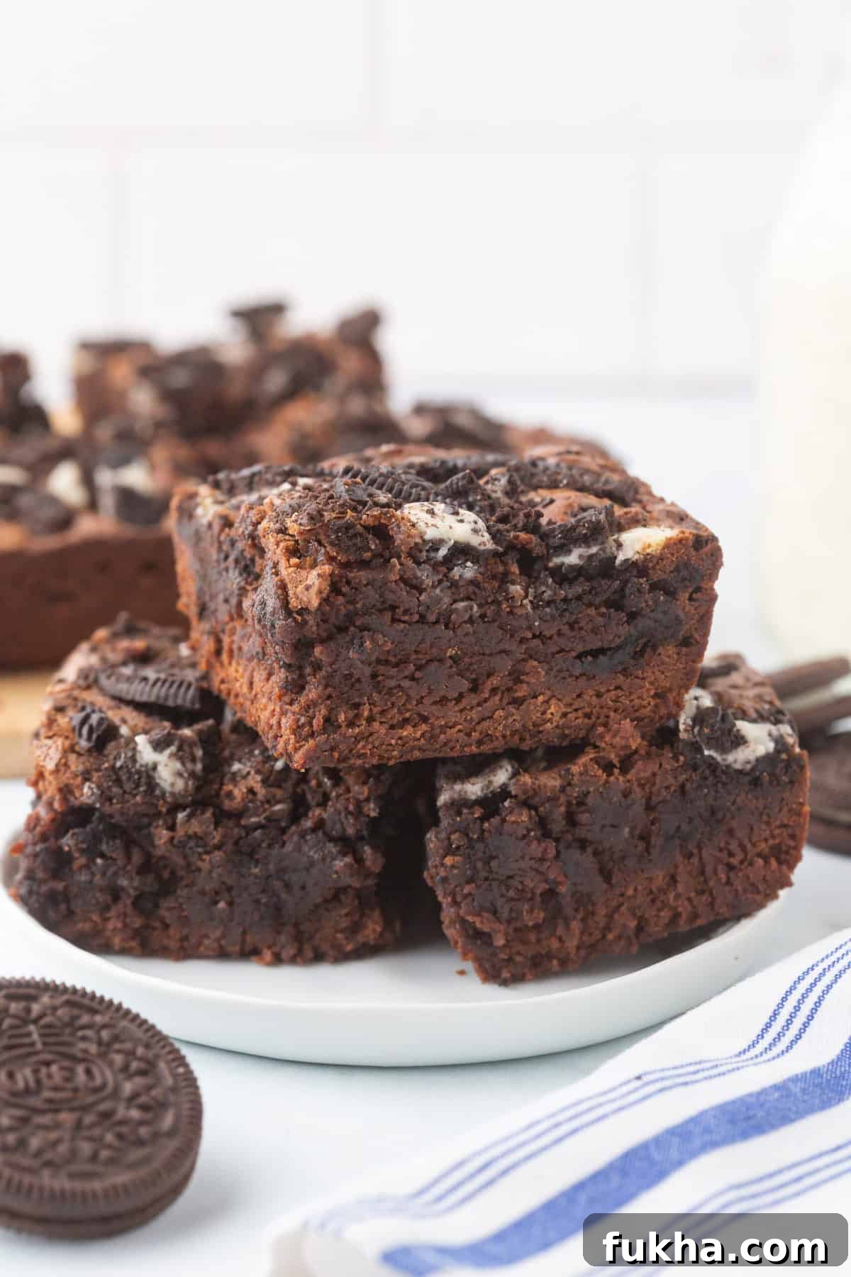 Fudgy Oreo-Stuffed Brownies Recipe 9 Stack of three oreo brownies served on a white plate.