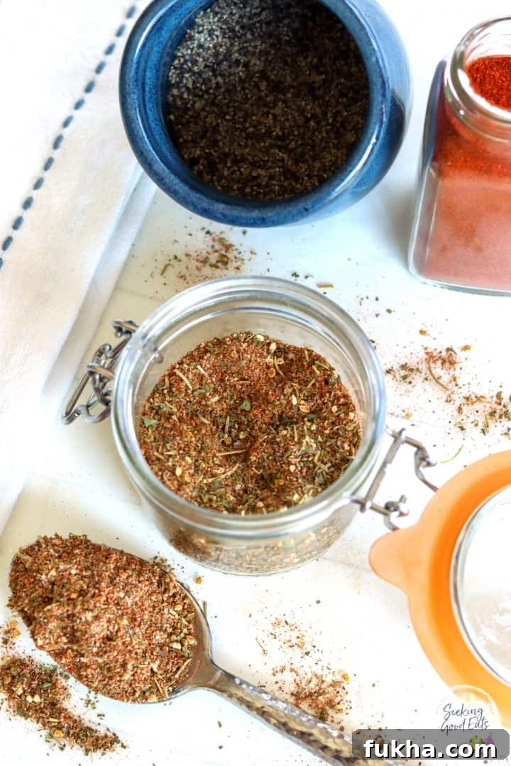 looking down on a clear jar of lamb rub seasoning surrounded by seasonings