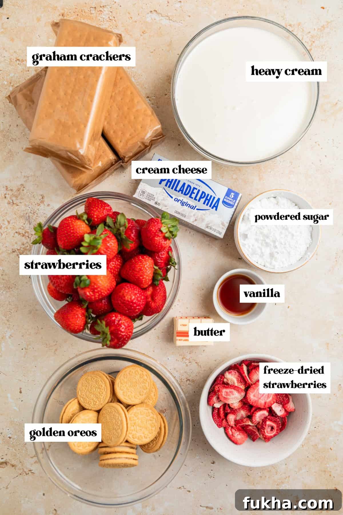 Graham crackers, whipping cream, vanilla, cream cheese and other ingredients labeled on surface.