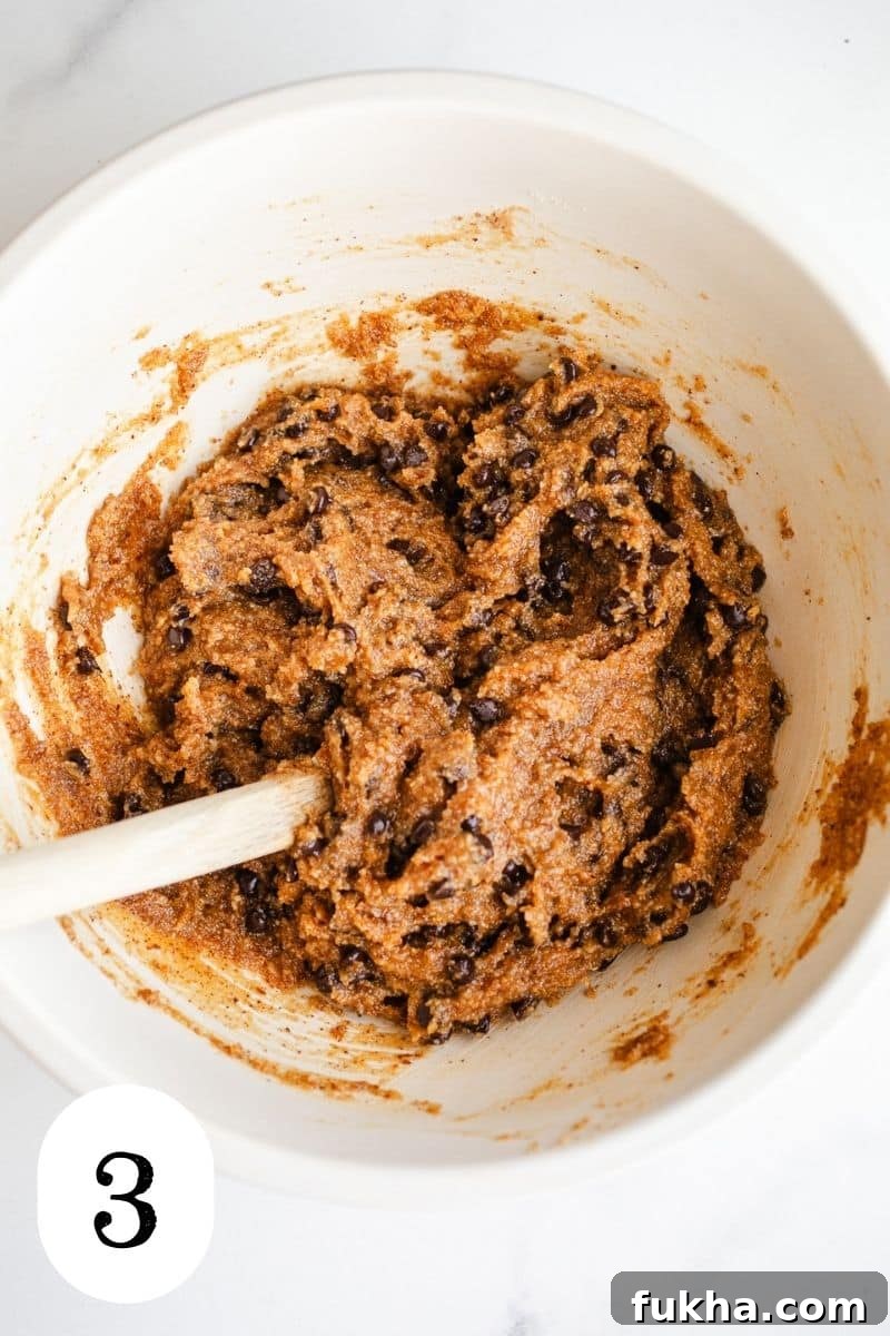 Cookie dough with chocolate chips in a mixing bowl.