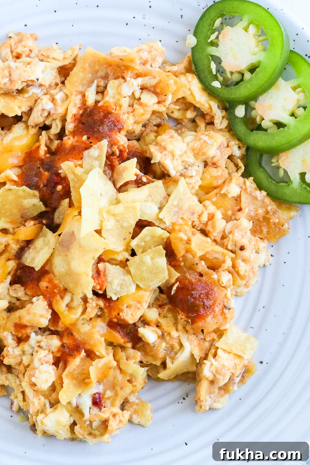 crunched tortilla chips in bite size piece on top of scrambled eggs