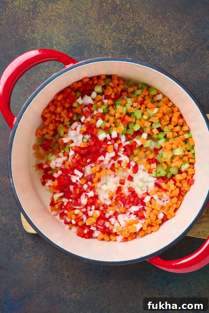 Sauteeing onions, carrots, celery and red bell peppers in soup pot.