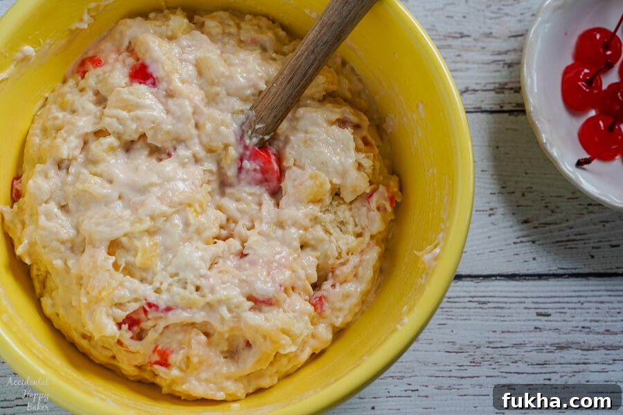 A yellow bowl of muffin batter, mixed and ready to fill a muffin tin.