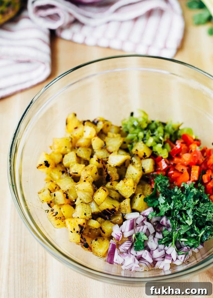 mixing grilled pineapple with peppers, onions, and cilantro in a bowl