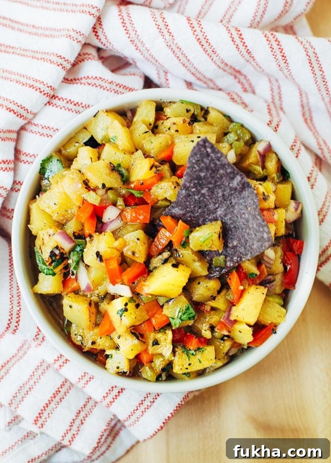 pineapple salsa in a bowl with a blue corn chip