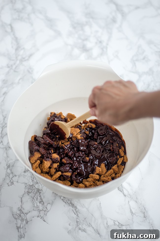 mixing melted chocolate and biscuits together in a bowl
